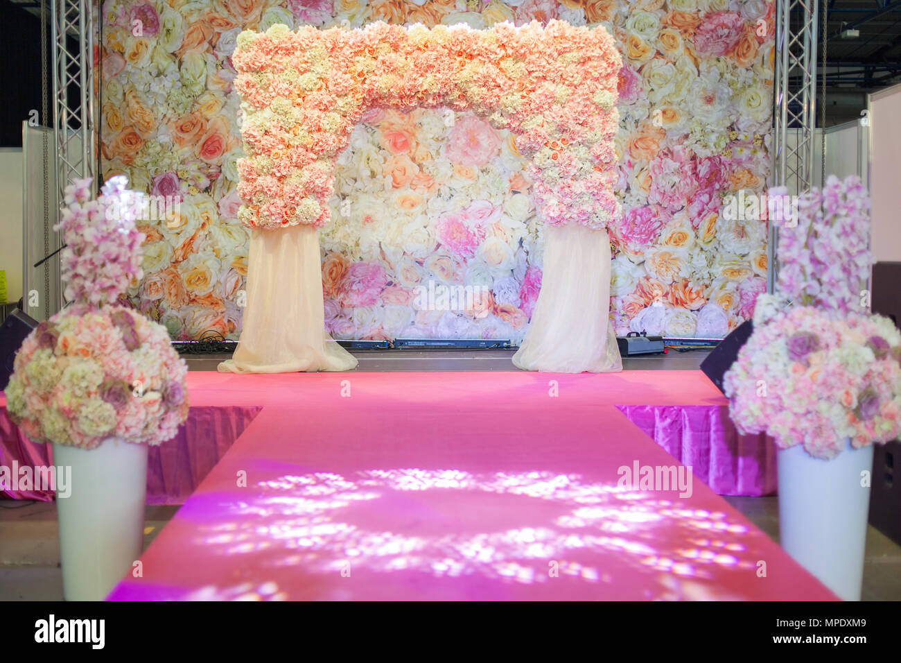 Beautiful arch of flowers for the wedding celebration on the podium. Stock Photo