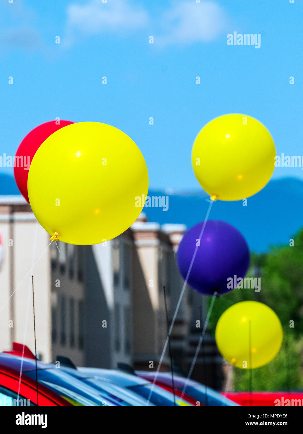 Colorful balloons; windy day; automobile dealership; Salida; Colorado