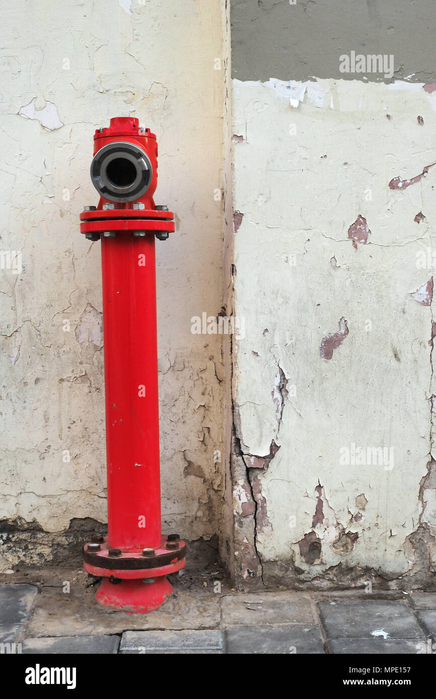 Old vintage street fire crane on the background of an old wall ...