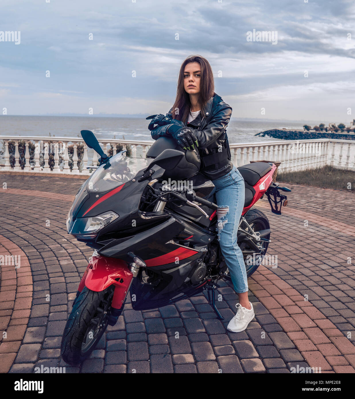 Biker girl in a leather jacket on a black and red color motorcycle Stock  Photo - Alamy