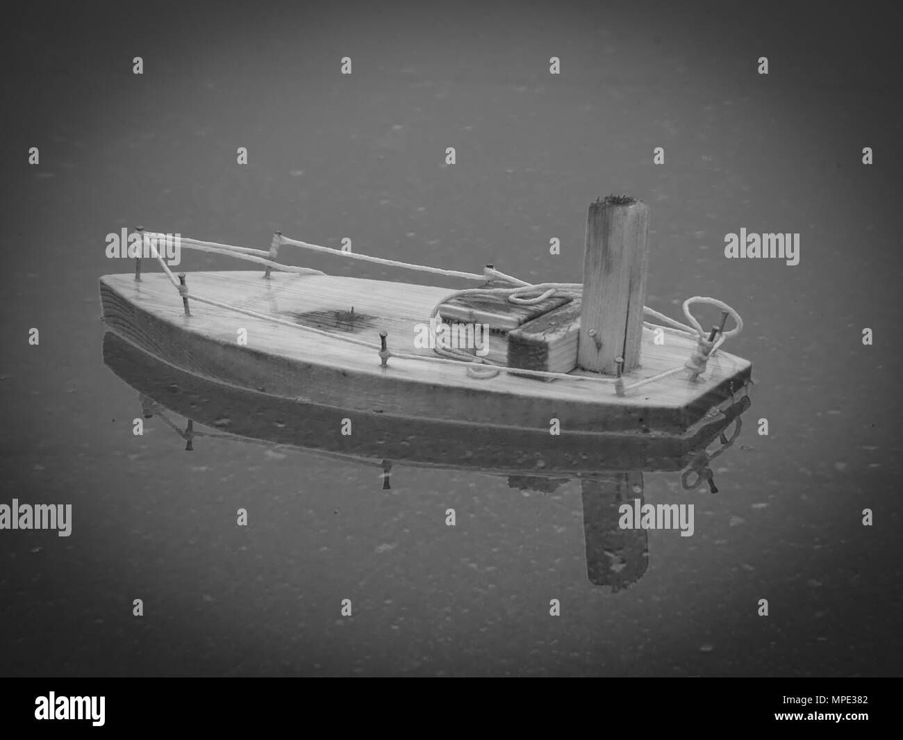Wooden toy boat floating rainy water black and white Stock Photo - Alamy
