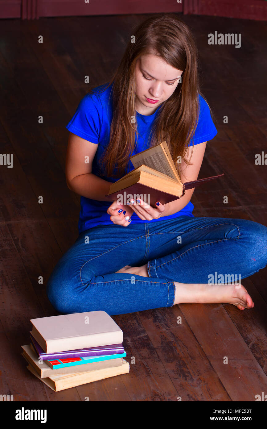 A girl sits on the floor in the library Stock Photo - Alamy