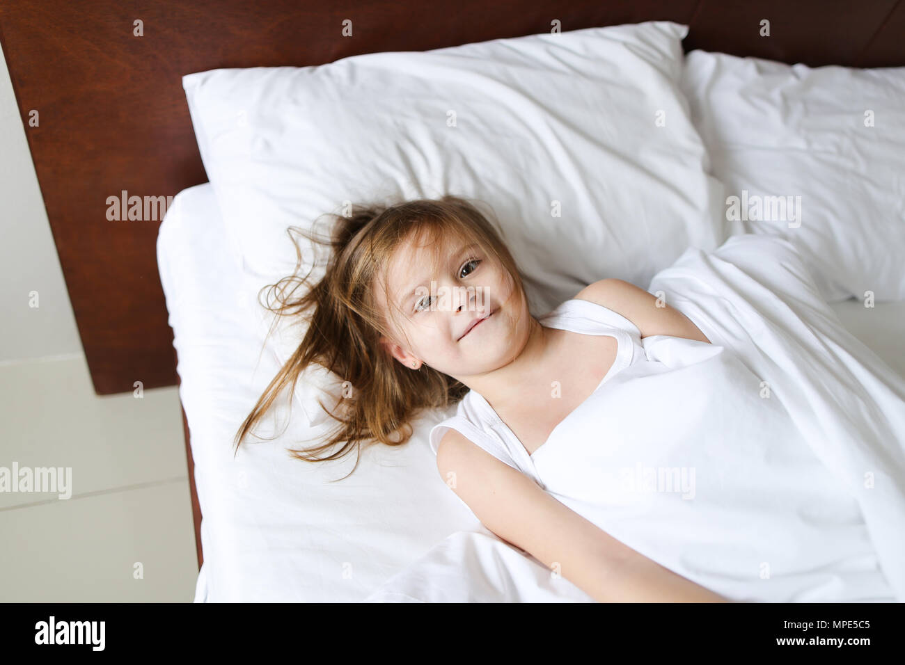 Little Girl Lying In Bed And Smiling In Morning Stock Photo Alamy
