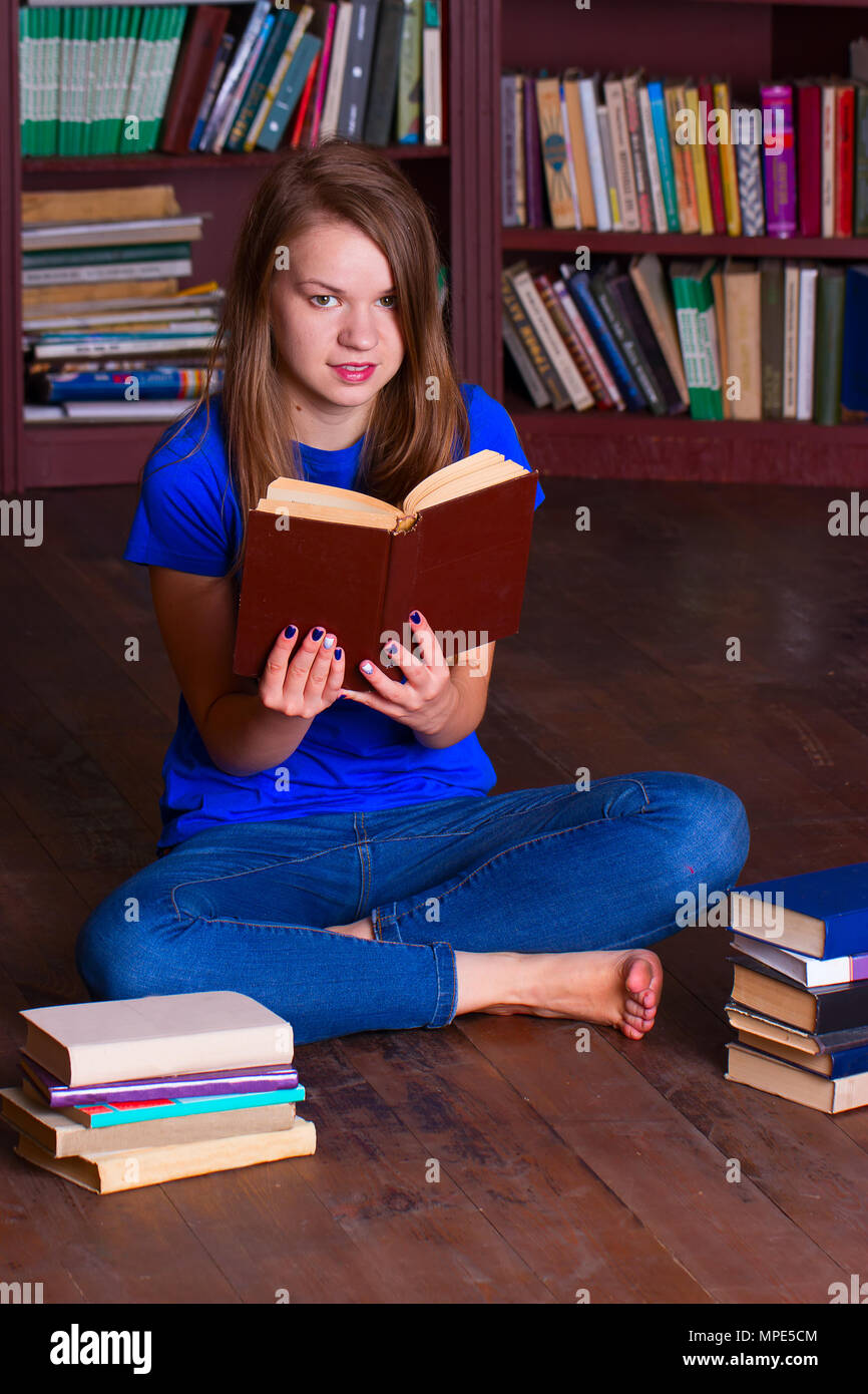 A girl sits on the floor in the library Stock Photo - Alamy