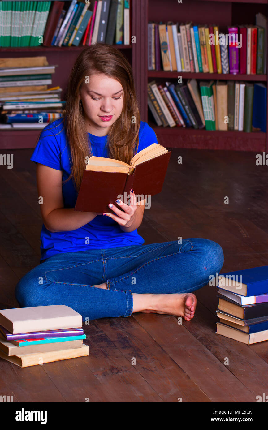 A girl sits on the floor in the library Stock Photo - Alamy