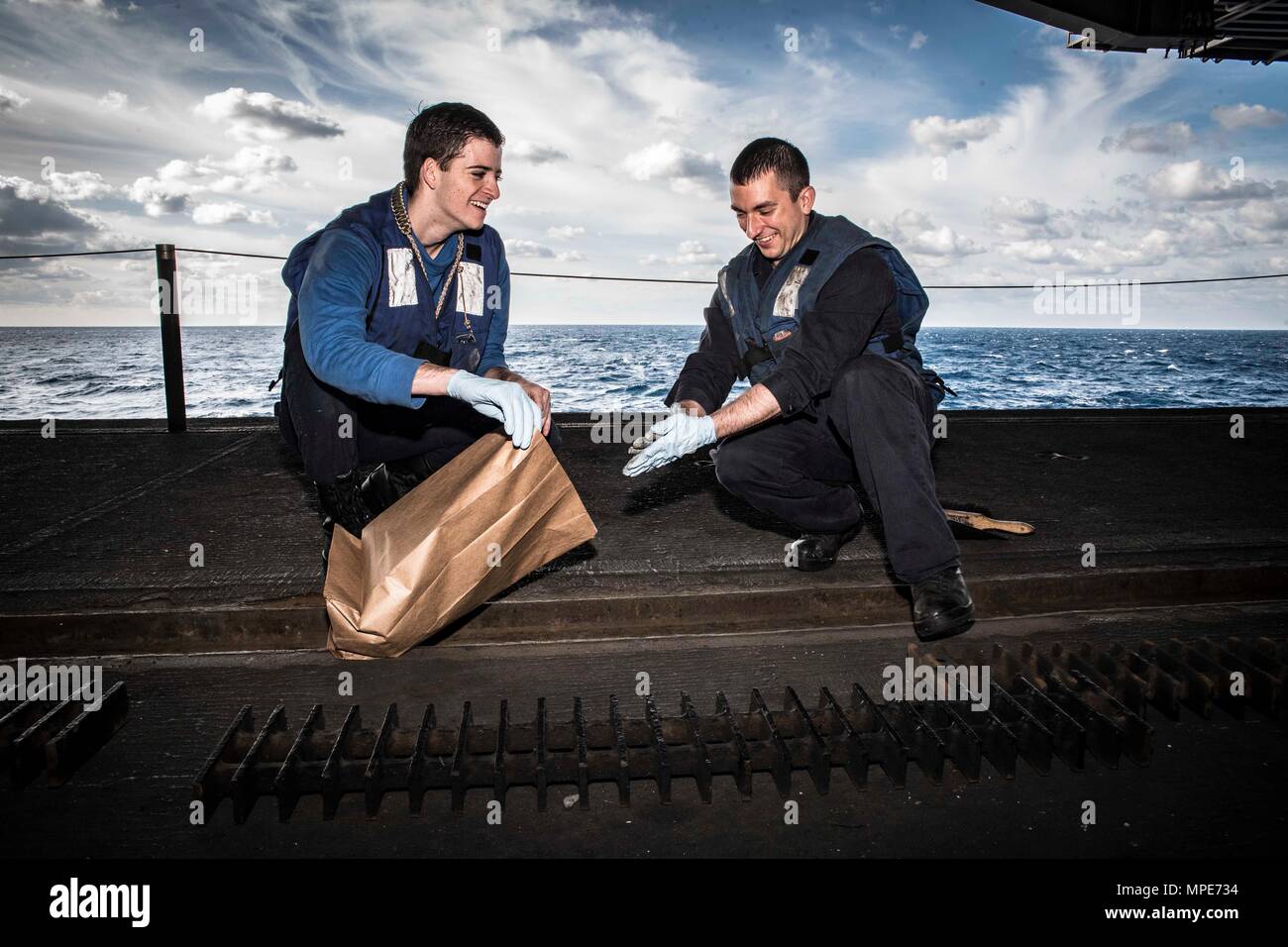 170207-N-IE397-040 ATLANTIC OCEAN  (Feb 7, 2017) Airman Devan Batie, from Salt Lake City, left, and Airman Chris Dukette, from Chicopee, Mass., remove debris from a deck drain in the hangar bay of the aircraft carrier USS Dwight D. Eisenhower (CVN 69). The ship is conducting aircraft carrier qualifications during the sustainment phase of the Optimized Fleet Response Plan (OFRP). (U.S. Navy photo by Mass Communication Specialist 3rd Class Christopher A. Michaels/Released) Stock Photo