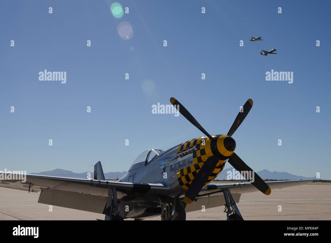 A P-47 Thunderbolt and a U.S. Air Force A-10C Thunderbolt II fly above a P-51 Mustang during the 2017 Heritage Flight Training and Certification Course at Davis-Monthan Air Force Base, Ariz., Feb. 10, 2017. The HFTCC provides civilian and military pilots the opportunity to practice flying in formation together in preparation for future air shows. (U.S. Air Force photo by Senior Airman Ashley N. Steffen) Stock Photo