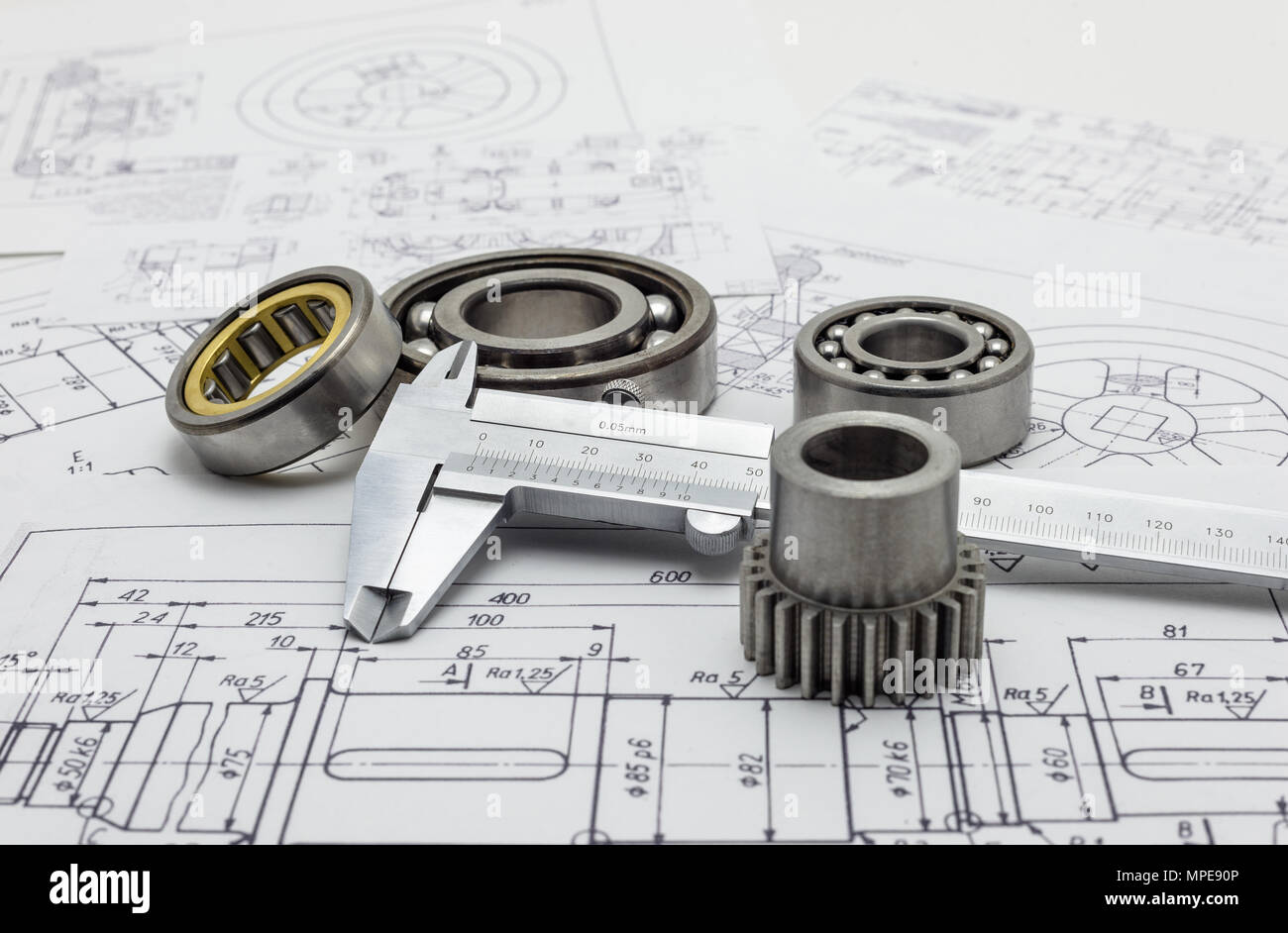 Vernier caliper lying on mechanical scheme with bearing and small gear