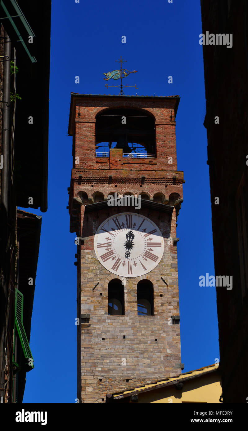 Lucca medieval 'Torre delle Ore' (Clock Tower), seen from a narrow street in city historic center Stock Photo