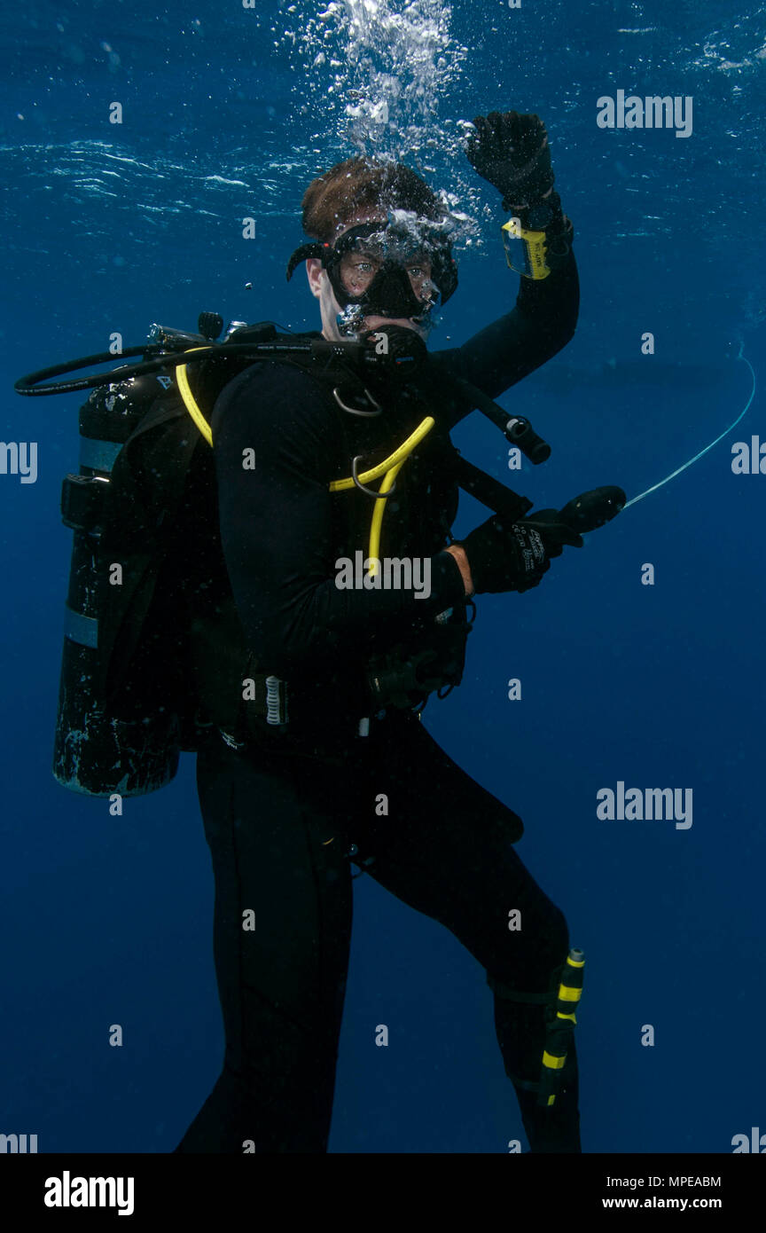 Construction Electrician 2nd Class Ben Coulson, assigned to Underwater Construction Team (UCT) 1, ascends the water column on his way to the surface during diver qualification training on Naval Station Guantanamo Bay, Feb. 12, 2017. UCT 1 provides a capability for construction, inspection, repair and maintenance of ocean facilities in support of Naval operations. (U.S. Navy Combat Camera photo by Mass Communication Specialist 1st Class Blake Midnight) Stock Photo