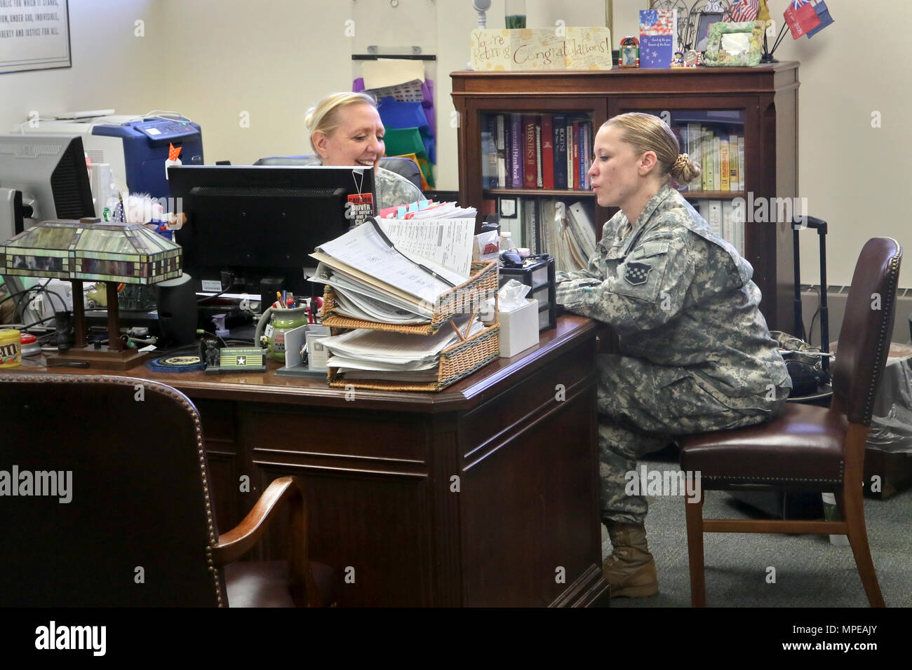 Army Sgt. 1st Class Deborah Hartman of the 318th Press Camp Headquarters speaks with Army Staff Sgt. Carrie Castillo during her last day as the unit administrator during the 318th battle assembly weekend, Forest Park, Ill., February 11, 2017. (U.S Army photo by Sgt. Alfonso Corral) Stock Photo