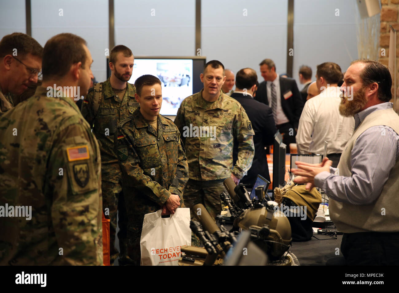 U.S. Army and German Army signal officers receive a briefing from a ...