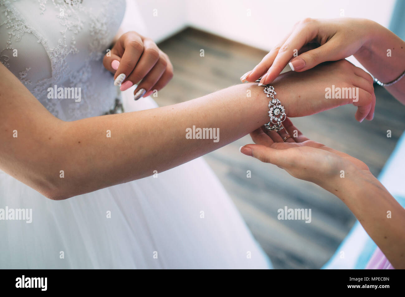 Close-up of woman Adjusting Wedding jewelry bracelet for Bride Stock Photo