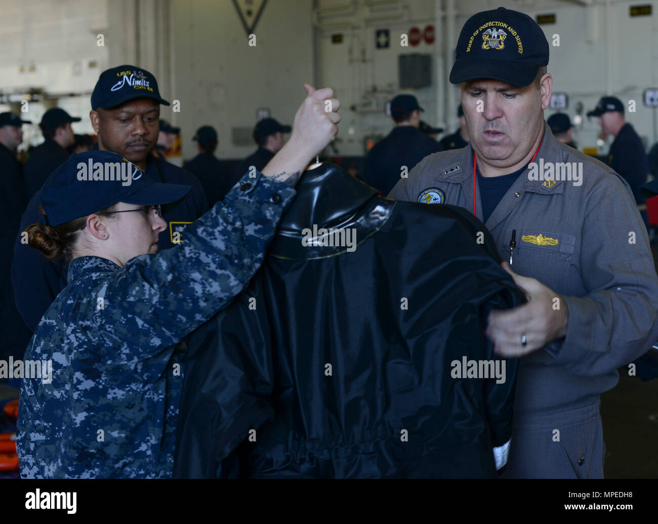 SAN DIEGO (Feb. 13, 2017) - Chief Warrant Officer 4 Richard Barr, a member of the Board of Inspection and Survey (INSURV) team, inspects a search and rescue wetsuit during a demonstration on board the aircraft carrier USS Nimitz (CVN 68). Nimitz is currently undergoing INSURV in preparation for an upcoming 2017 deployment. (U.S. Navy photo by Mass Communication Specialist 3rd Class Samuel Bacon/Released) Stock Photo