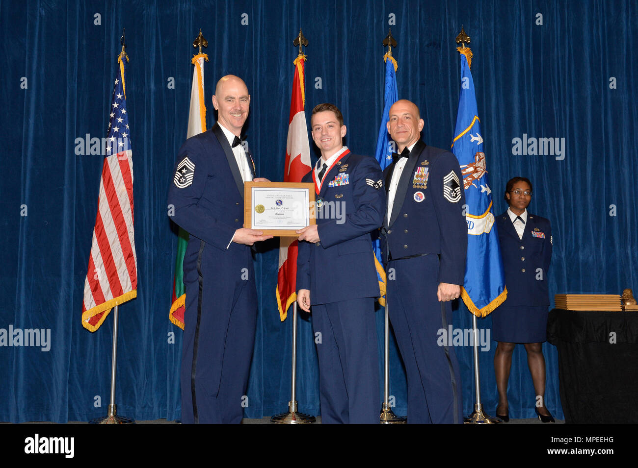 Senior Airman Alex Luft, center, receives the Distinguished Graduate Award  for Airman leadership school class 17-3 from Chief Master Sgt. Ronald  Anderson, Chief Master Sgt. of the Air National Guard, and Chief