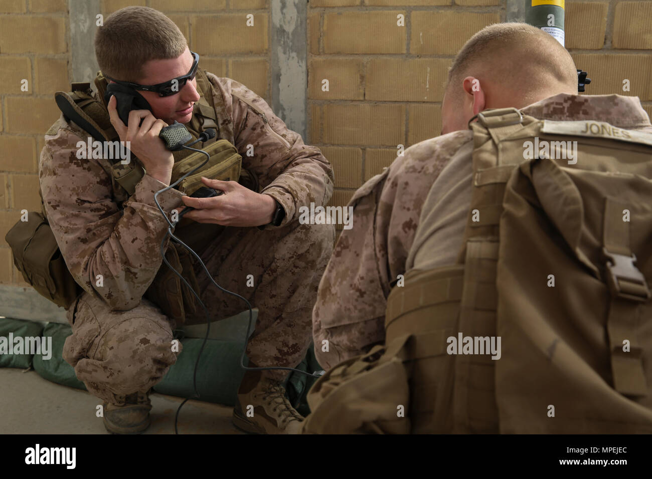 Sgt. Adam Tabor, radio chief with 4th Air Naval Gunfire Liaison Company and Cpl. Brian Jones, a field radio operator with Special Purpose Marine Air-Ground Task Force-Crisis Response-Central Command, establish communication with range operations during a close air support exercise while forward deployed to the Middle East Feb. 9, 2017. Coalition interoperability was the primary mission of the event and was an opportunity for the joint terminal attack controllers to become more proficient with their skills. SPMAGTF-CR-CC Marines consistently train to enhance their ability to react to any obstac Stock Photo