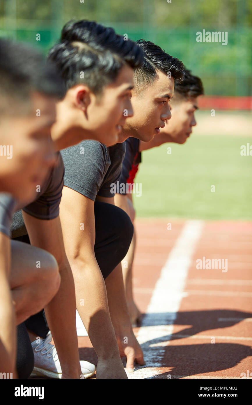 close-up of faces of young asian adult runners on starting line. Stock Photo