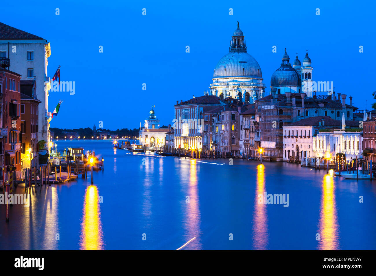 Grand Canal and Basilica di Santa Maria della Salute at twilight, blue hour, dusk, Dorsoduro, Venice,  Veneto, Italy. Long exposure, light trails, lig Stock Photo
