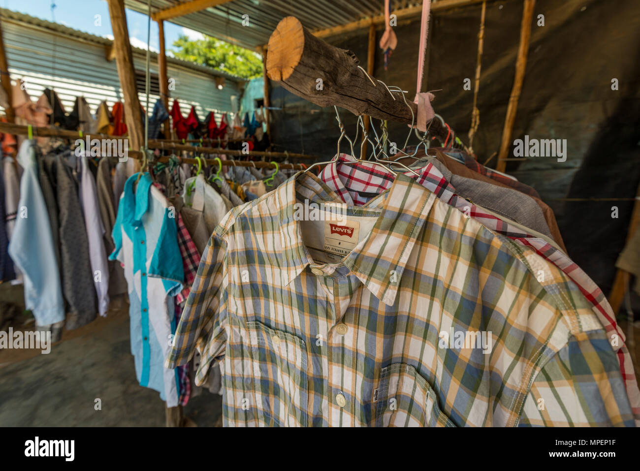 A tourist browses clothes in an informal shop in Inhassoro Mozambique. Stock Photo