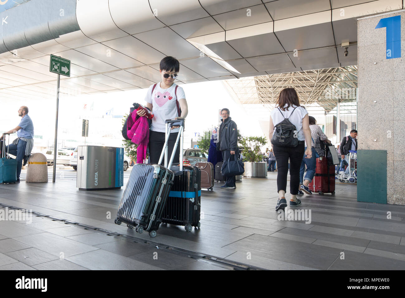 Rome Fiumicino airport, passengers walking with trolley and suitcase ...