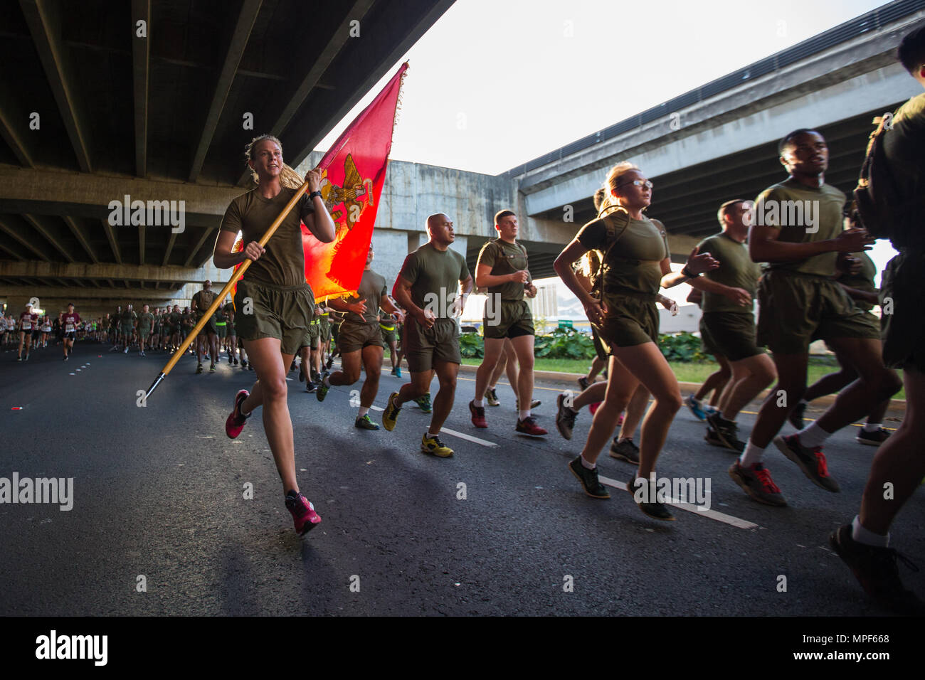 U.S. Marine Corps Sgt. Melissa Bukowski, supply chief with U.S. Marine Corps Forces, Pacific, carries the Headquarters and Service Battalion, during the 33rd Annual Great Aloha Run in Honolulu, Hawaii, Feb. 20, 2017. Over 20,000 runners took part in the 8.15-mile run from the Aloha tower to the Aloha Stadium. (U.S. Marine Corps photo by Lance Cpl. Miguel A. Rosales) Stock Photo