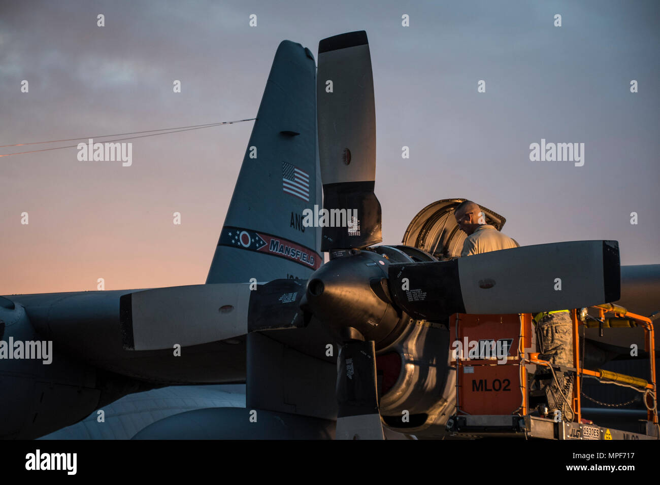 179th Airlift Wing Maintenance members work on the engine of a C-130H Hercules as the sun rises, Feb. 21, 2017, at the 179th Airlift Wing, Mansfield, Ohio.  The 179th Airlift Wing is always on mission to be the first choice to respond to community, state and federal missions with a trusted team of highly qualified Airmen. (U.S. Air National Guard photo by 1st Lt. Paul Stennett/Released) Stock Photo