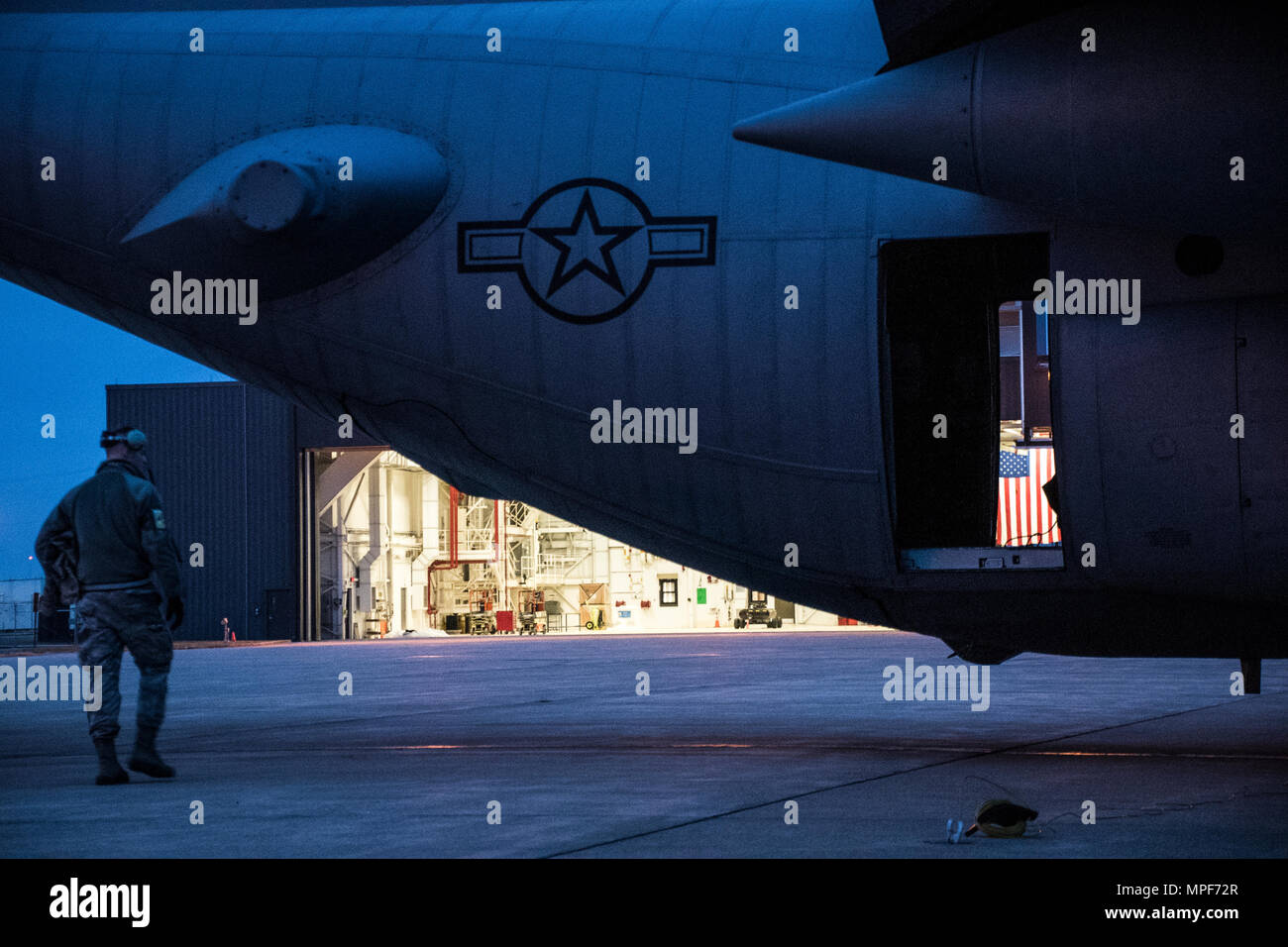 179th Airlift Wing Maintenance members move one of the C-130H Hercules out of a hangar as the sun rises, Feb. 21, 2017, at the 179th Airlift Wing, Mansfield, Ohio.  The 179th Airlift Wing is always on mission to be the first choice to respond to community, state and federal missions with a trusted team of highly qualified Airmen. (U.S. Air National Guard photo by 1st Lt. Paul Stennett/Released) Stock Photo