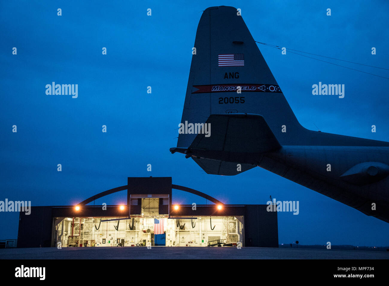 179th Airlift Wing Maintenance members move one of the C-130H Hercules out of a hangar as the sun rises, Feb. 21, 2017, at the 179th Airlift Wing, Mansfield, Ohio.  The 179th Airlift Wing is always on mission to be the first choice to respond to community, state and federal missions with a trusted team of highly qualified Airmen. (U.S. Air National Guard photo by 1st Lt. Paul Stennett/Released) Stock Photo