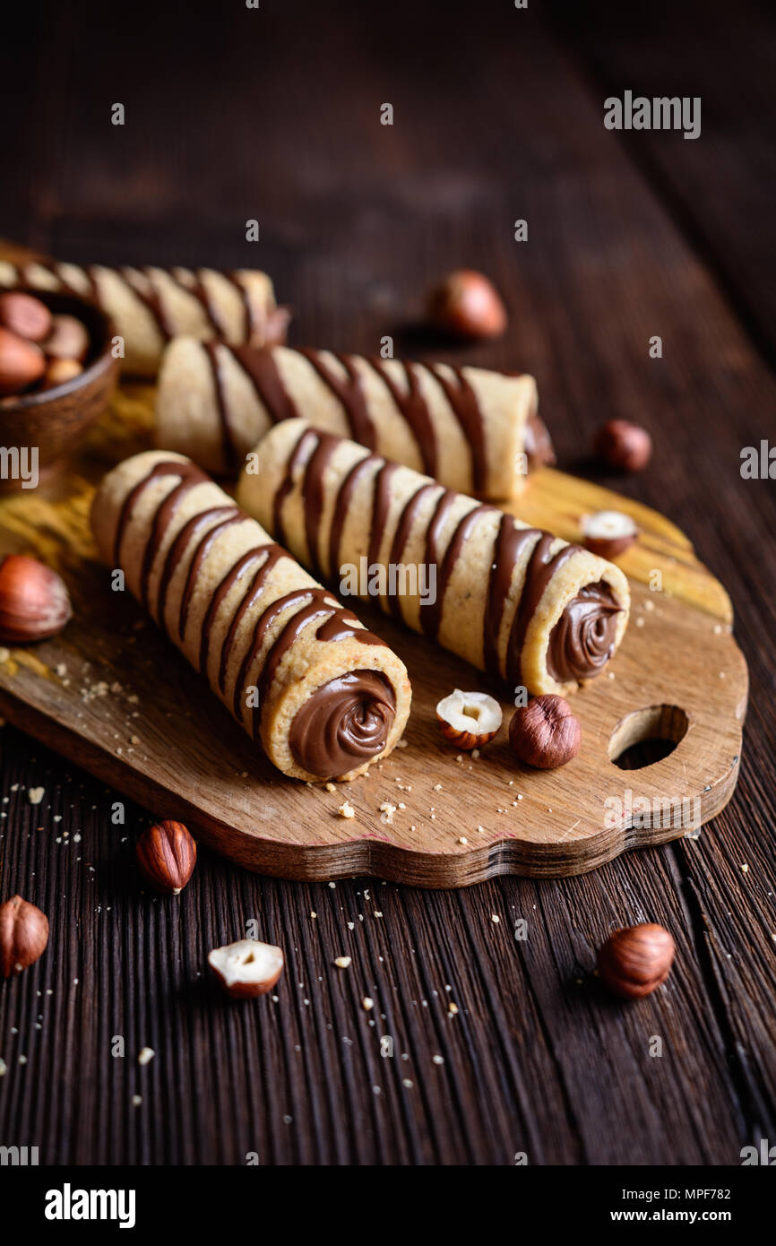 Delicious biscuit tubes filled with hazelnut cream and chocolate topping  Stock Photo - Alamy