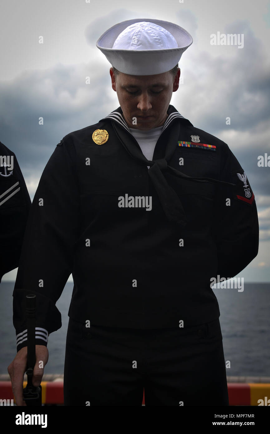 navy master at arms dress blues ATLANTIC OCEAN (Feb. 18, 2017) – Master-at-Arms 3rd Class Andrew Crum bows  his head in prayer during a burial-at-sea ceremony held on the amphibious  assault ship USS Iwo Jima (LHD 7). Sailors