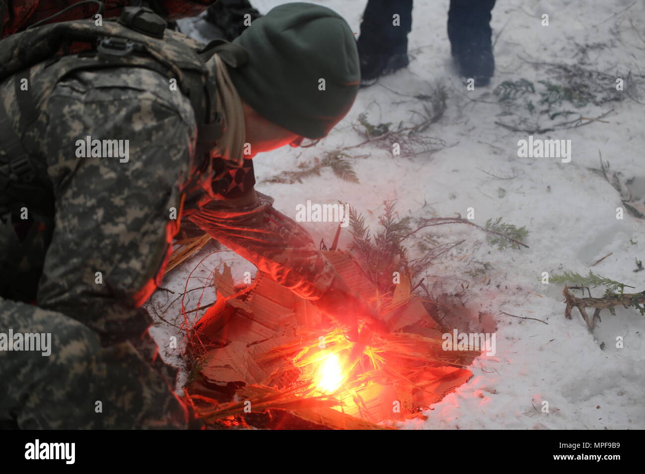 Soldiers from Delta Company, 898th Brigade Engineer Battalion build fires as part of their unit’s basic winter survival training, Feb. 11, 2017, Ranger Creek State Airport near Enumclaw, Wash. Building a fire using natural materials is a crucial skill in surviving the harsh elements of frigid climates. (U.S. Army National Guard Photo by Spc. Tyler Main) Stock Photo
