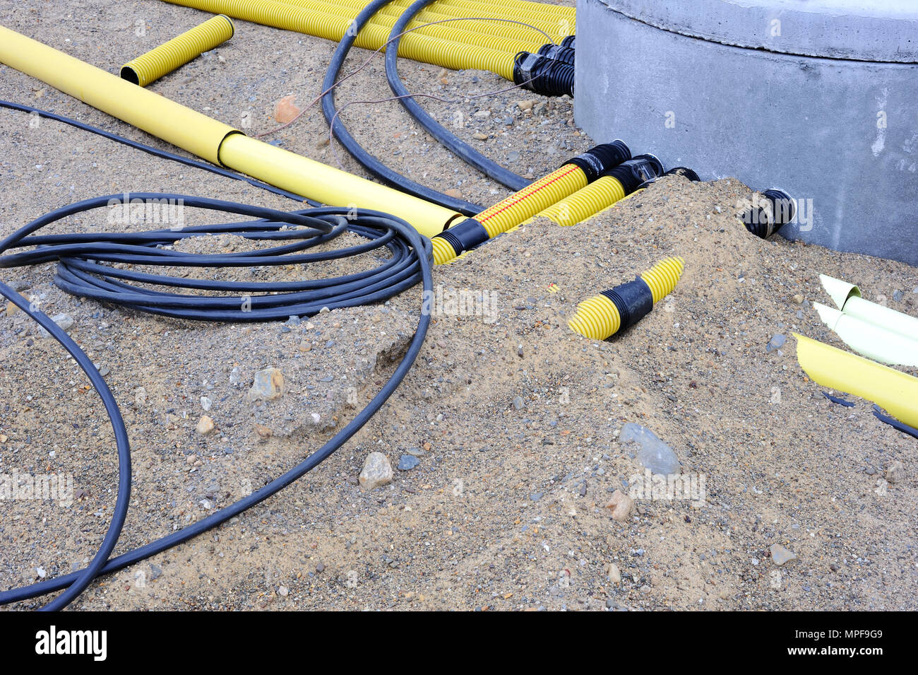 Electric cables and plastic pipes in the sand Stock Photo Alamy