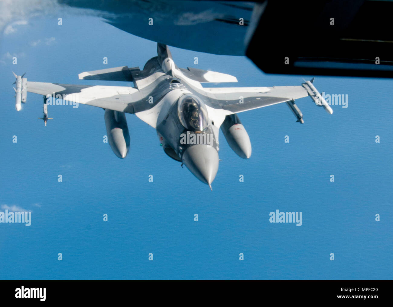 YIGO, Guam (Feb. 21, 2017) An F-16 jet pulls away from a Boeing KC-135 Stratotanker after an in-flight refueling evolution near Guam during Exercise Cope North 2017, Feb. 21. The exercise includes 22 total flying units and more than 1,700 personnel from three countries and continues the growth of strong, interoperable relationships within the Indo-Asia-Pacific Region through integration of airborne and land-based command and control assets. (U.S. Navy photo by Mass Communication Specialist Seaman Heather C. Wamsley/Released) Stock Photo