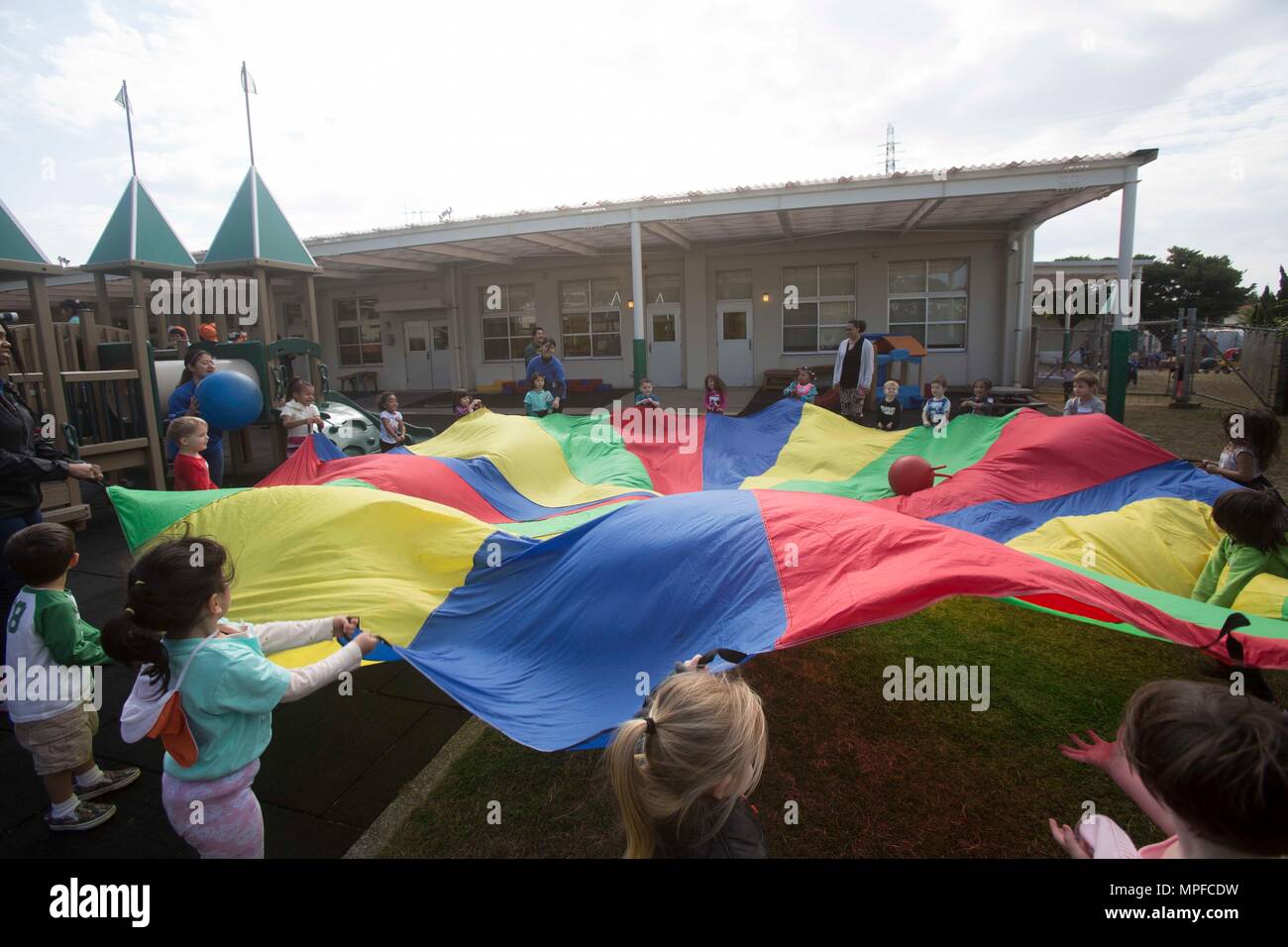 CAMP COURTNEY, OKINAWA, Japan—Children play with a parachute during a  friendship day at the Chura Warabi Center Feb. 16 aboard Camp Courtney,  Okinawa, Japan. The children's faces lit up with smiles when