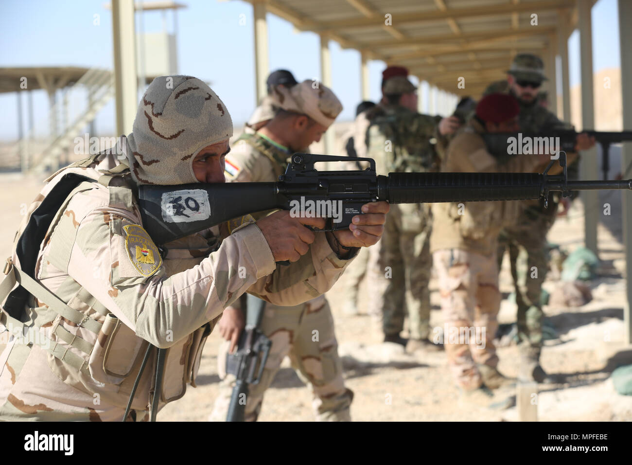 Iraqi security forces soldiers practice the standing position during weapons training at Al Asad Air Base, Iraq, Feb. 23, 2017.  This training is part of the overall Combined Joint Task Force – Operation Inherent Resolve building partner capacity mission to train and improve the capability of partnered forces fighting ISIS. CJTF-OIR is the global Coalition to defeat ISIS in Iraq and Syria. (U.S. Army photo by Sgt. Lisa Soy) Stock Photo