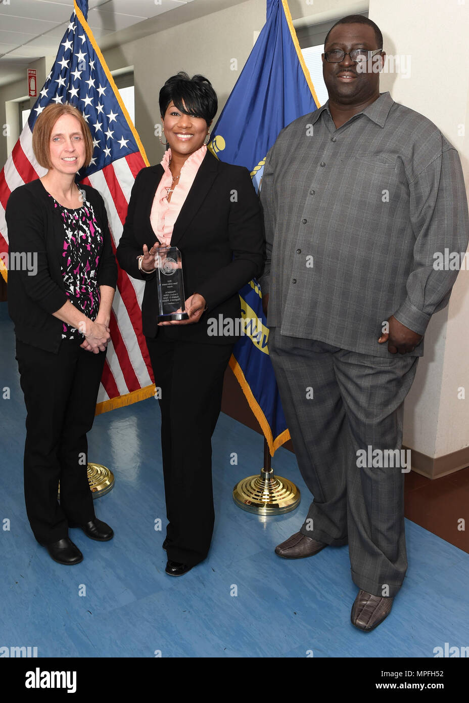170228-N-PG340-005 PORTSMOUTH, Va. (Feb. 28, 2017) Navy Medicine East (NME) budget team with the Annual American Society of Military Comptrollers Team Achievement Award they received Feb. 23 (from left to right):  Carolyn Atkins, financial management analyst; Rashelle D. Taylor, budget department head; and Fitzgerald Wheeler, financial management analyst. NME is one of two regional commands that manage Navy Medicine's global health care network by overseeing the delivery of medical, dental and other health care services to approximately one million patients across almost 100 facilities across  Stock Photo