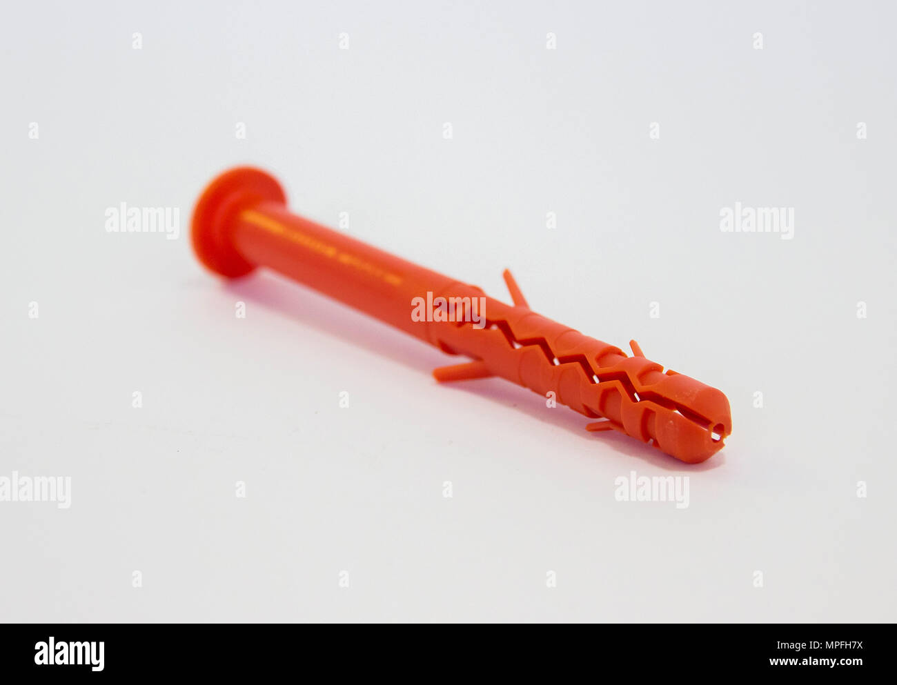 One plastic orange dowel on white background Stock Photo