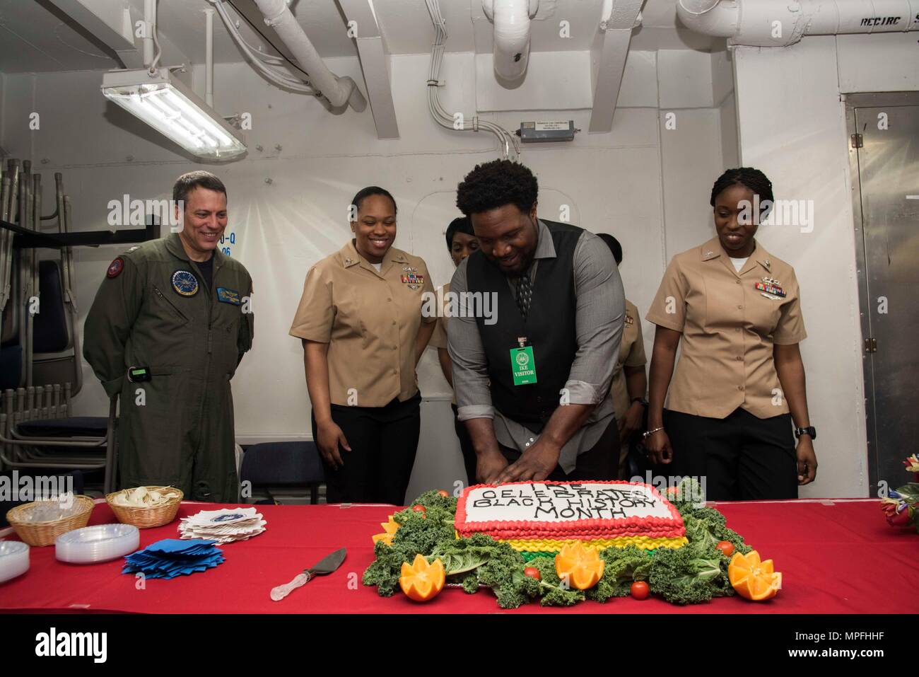170228-N-KJ380-073  NORFOLK, Va. (Feb. 28, 2017) Joseph Matthews, M.A., a guest speaker from the Columbia University Teachers College, cuts the cake for the aircraft carrier USS Dwight D. Eisenhower's (CVN 69) (Ike) Black History Month celebration in the Five-Star classroom aboard the aircraft carrier USS Dwight D. Eisenhower (CVN 69) (Ike). Ike is currently pier side during the sustainment phase of the Optimized Fleet Response Plan (OFRP). (U.S. Navy photo by Mass Communication Specialist Seaman Neo Greene III) Stock Photo