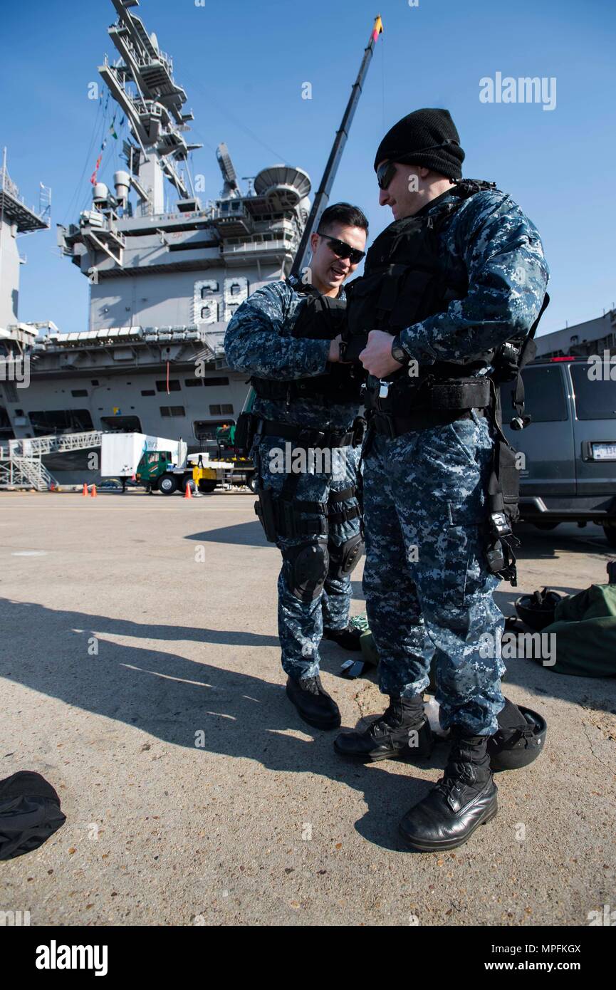 170306-N-OS569-011  NORFOLK, Va. (March 6, 2017) Ensign Sean Jackson, left, helps Culinary Specialist 2nd Class Justin Graham, prepare for a visit, board, search, and seizure drill on a pier at Naval Base Norfolk. Both Sailors are currently assigned to the guided-missile destroyer USS Winston Churchill (DDG 81). (U.S. Navy photo by Mass Communication Specialist Seaman Zach Sleeper) Stock Photo