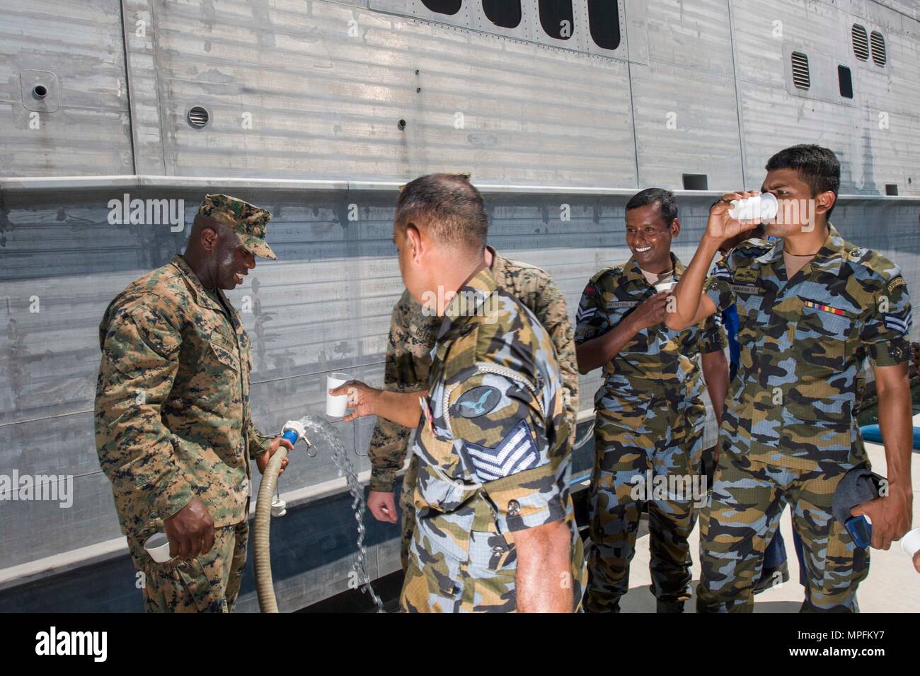 170308-N-SF984-057   HAMBANTOTA, Sri Lanka (March 8, 2017) SSgt. Devario Graham, embarked on USNS Fall River (T-EPF 4) and Sri Lankan military personnel drink purified sea water after conducting water purification training on the pier as part of Pacific Partnership 2017. Pacific Partnership is the largest annual multilateral humanitarian assistance and disaster relief preparedness mission conducted in the Indo-Asia-Pacific and aims to enhance regional coordination in areas such as medical readiness and preparedness for manmade and natural disasters. (U.S. Navy photo by Mass Communication Speci Stock Photo