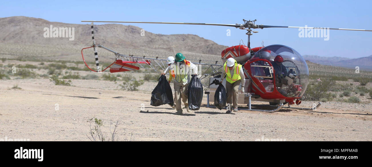 Employees from Natural Resources and Environmental Affairs, remove empty bins for desert tortoises from a helicopter during the Desert Tortoise translocation, April 10, 2017, which was facilitated by the Marine Corps Air Ground Combat Center, Twentynine Palms, Calif. The translocation, in accordance with the U.S. Fish and Wildlife Service-signed Biological Opinion, serves as a negotiated mitigation to support a congressionally mandated land expansion which, will afford the Combat Center the ability to conduct Large Scale Exercise training of a Marine Expeditionary Brigade-level force. Stock Photo