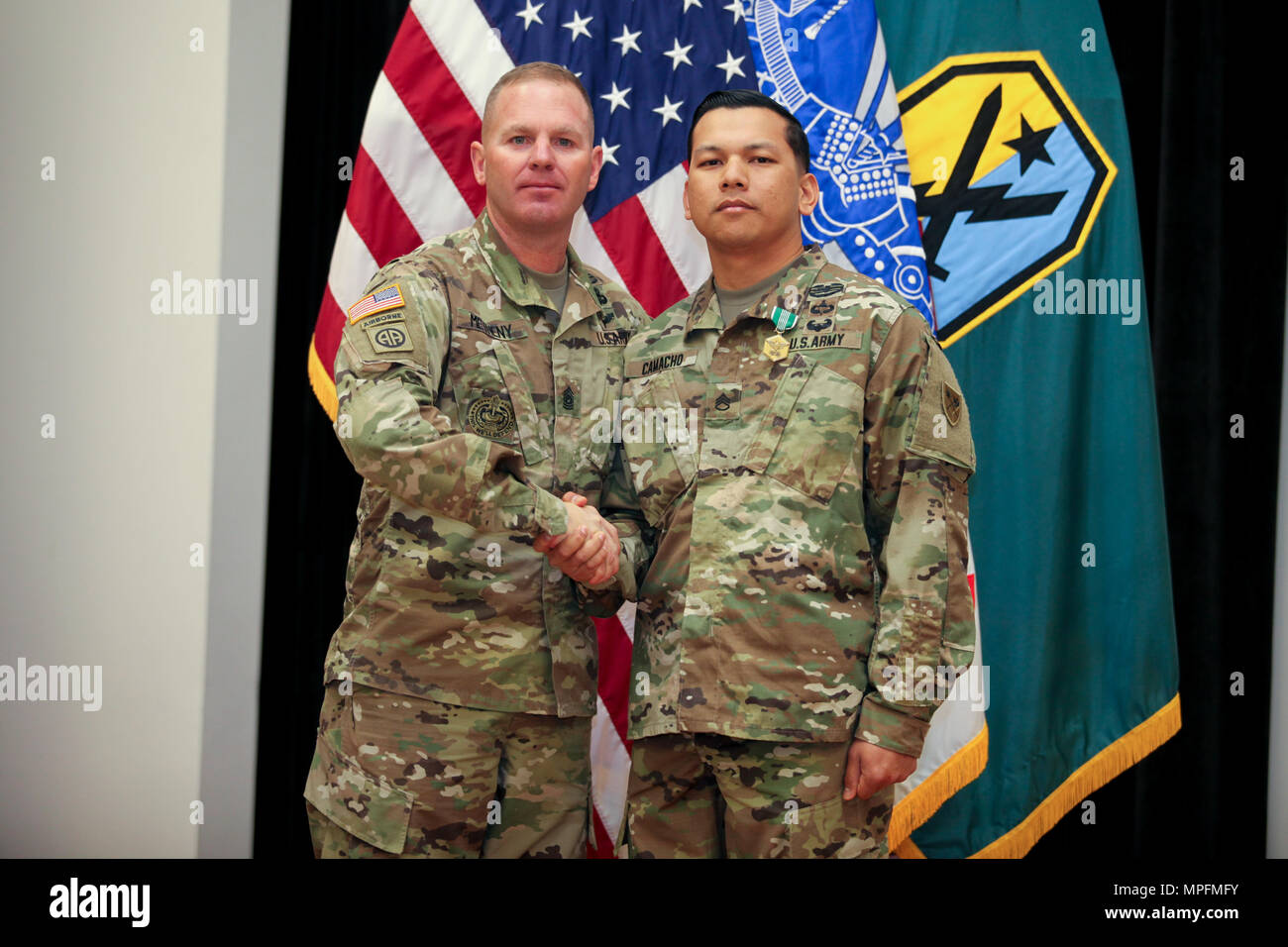 (FORT BENNING, Ga) Command Sgt. Maj. Timothy Metheny, Maneuver Center of Excellence command sergeant major, presents Staff Sgt. Michael J. Camacho of Charlie Company, 1st Battalion, 81st Armor Regiment with the Army Commendation Medal for winning the Platoon Sergeant of the Year category in the 2017 Fort Benning Best Warrior Competition, March 8, 2017, here, in Derby Auditorium at McGinnis-Wickam Hall. Camacho will compete in the Training and Doctrine Command Best Warrior Competition later this year. (Photos by: Markeith Horace/MCoE PAO Photographer) Stock Photo
