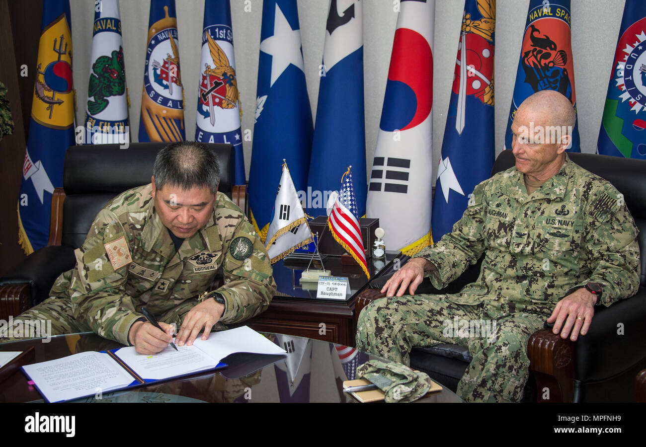 Commander, Republic of Korea (ROK) Naval Special Warfare Flotilla, Rear Adm. Jae Eun Lee, and Commander, Task Force 75, U.S. Navy Capt. Robert A. Baughman, sign an information exchange agreement in Jinhae, ROK, March 9, 2017, as part of exercise Foal Eagle 2017. The agreement addresses research and development practices between the two nations, promotes explosive ordnance disposal interoperability, and enhances future readiness. (U.S. Navy Combat Camera photo by Mass Communication Specialist 3rd Class Alfred A. Coffield) Stock Photo