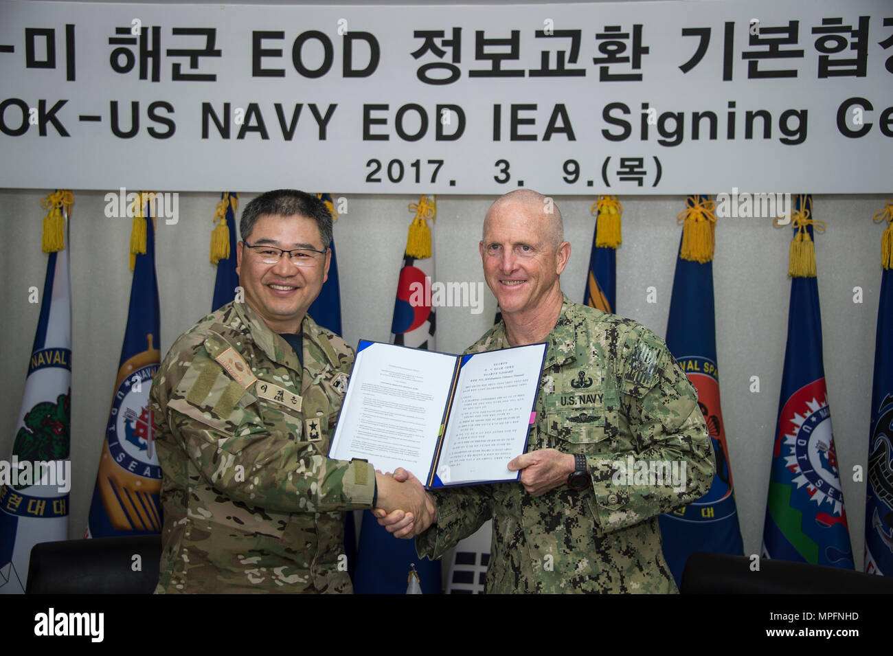 Commander, Republic of Korea (ROK) Naval Special Warfare Flotilla, Rear Adm. Jae Eun Lee, and Commander, Task Force 75, U.S. Navy Capt. Robert A. Baughman, shake hands after signing an information exchange agreement in Jinhae, ROK, March 9, 2017, as part of exercise Foal Eagle 2017. The agreement addresses research and development practices between the two nations, promotes explosive ordnance disposal interoperability, and enhances future readiness. (U.S. Navy Combat Camera photo by Mass Communication Specialist 3rd Class Alfred A. Coffield) Stock Photo