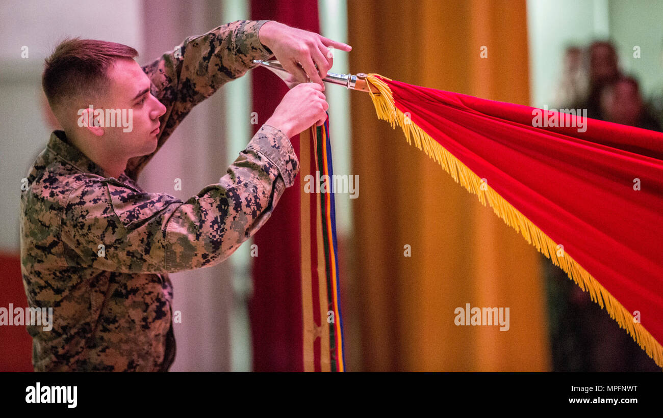 U.S. Marine with 3d Marine Division, 4th Marine Regiment attaches a battle streamer to the unit guidon during the 4th Marine Regiment 103rd battle colors rededication and awards ceremony on Camp Schwab, Okinawa, Japan, March 9, 2017. U.S. Marines, Sailors, and civilians participated in the ceremony to reflect on 103 years of accomplishments from 4th Marine Regiment as the “oldest” and the “proudest” regiment in the Corps to date. (U.S. Marine Corps photo by MCIPAC Combat Camera Lance Cpl. Jesus McCloud) Stock Photo