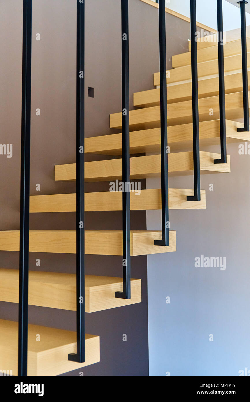 Floating stairs. Ash lumber stairs with metal railing attached to brown
