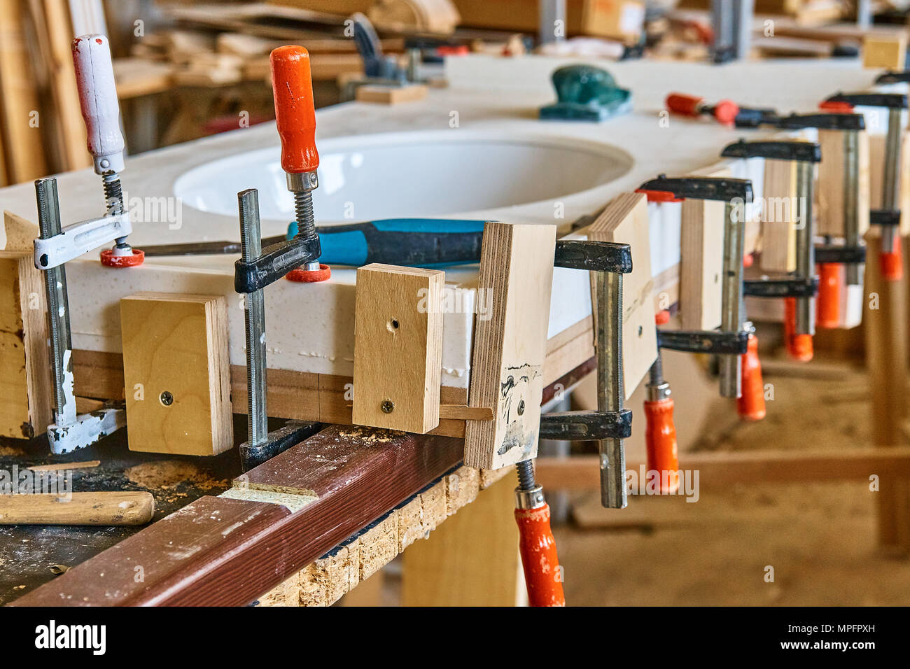 Joinery. Gluing and clamping table top of acrylic stone for single sink