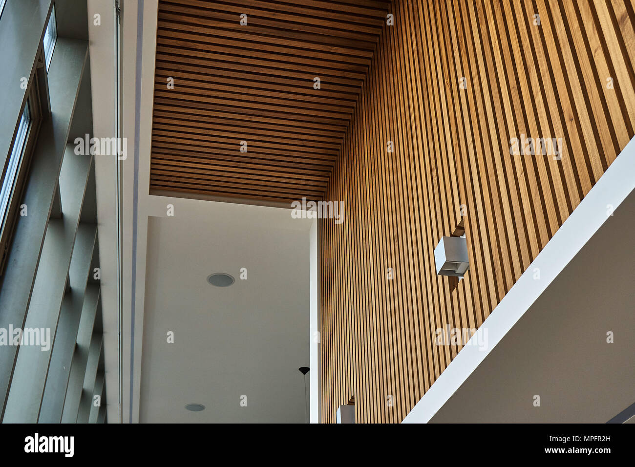 Walnut slats wall panel. Wooden slats on wall and ceiling in modern