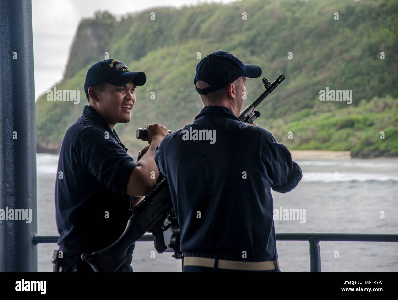 170307-N-DA434-085SANTA RITA, Guam (March 7, 2017) Gunner's Mate 2nd Class Kevin C. Barbo and Chief Machinist's Mate (Weapon) Shawn Quinton, assigned to the submarine tender USS Frank Cable (AS 40) Weapons Department, conduct force protection measures during sea and anchor, March 7.  Frank Cable, enroute to Portland, Ore. for her dry-dock phase maintenance availability, conducts maintenance and supports submarines and surface vessels deployed to the Indo-Asia-Pacific region. (U.S. Navy photo by Mass Communication Specialist 3rd Class Alana Langdon/Released) Stock Photo