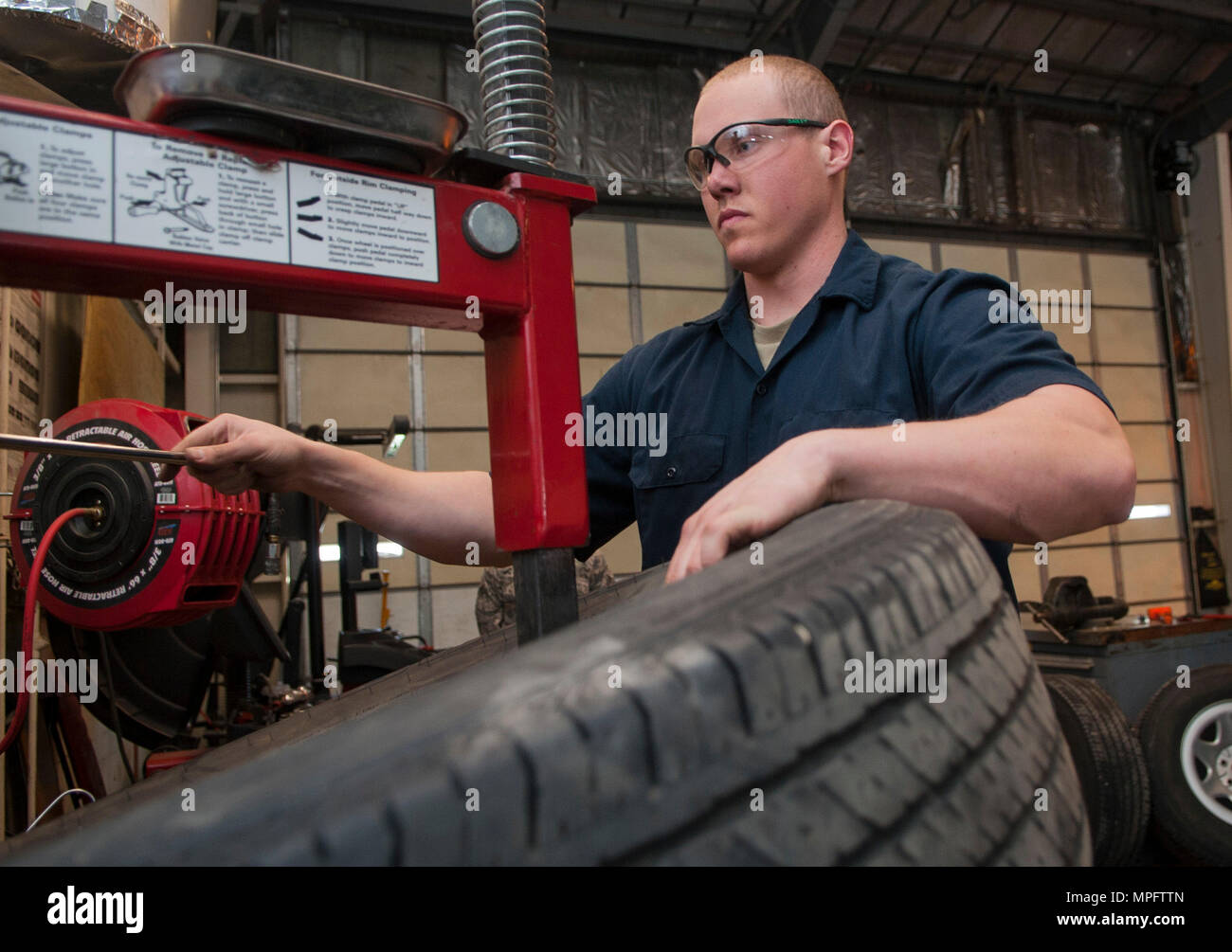 Senior Airman Nicholas Oukrop, 5th Logistics Readiness Squadron vehicle maintenance technician, replaces an old tire at Minot Air Force Base, N.D., Feb.28, 2017. The maintainers use a tire clamp machine to remove each tire from its rim while performing maintenance. (U.S. Air Force photo/Airman 1st Class Jonathan McElderry) Stock Photo